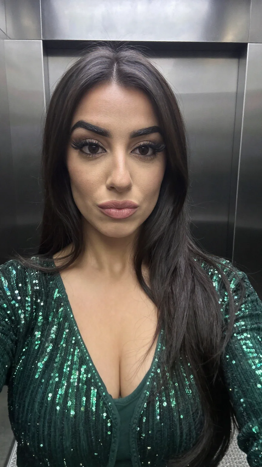Middle-eastern woman selfie in green sequin dress in elevator